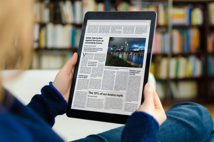Person reading a news website on a tablet