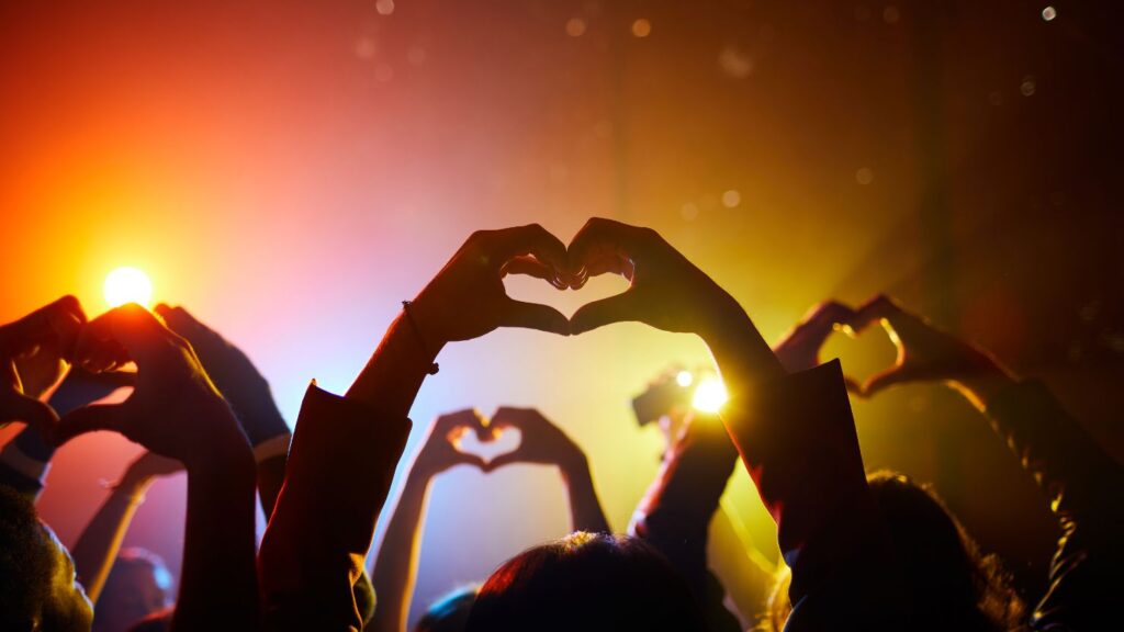 fans joining their hands in a shape of a heart