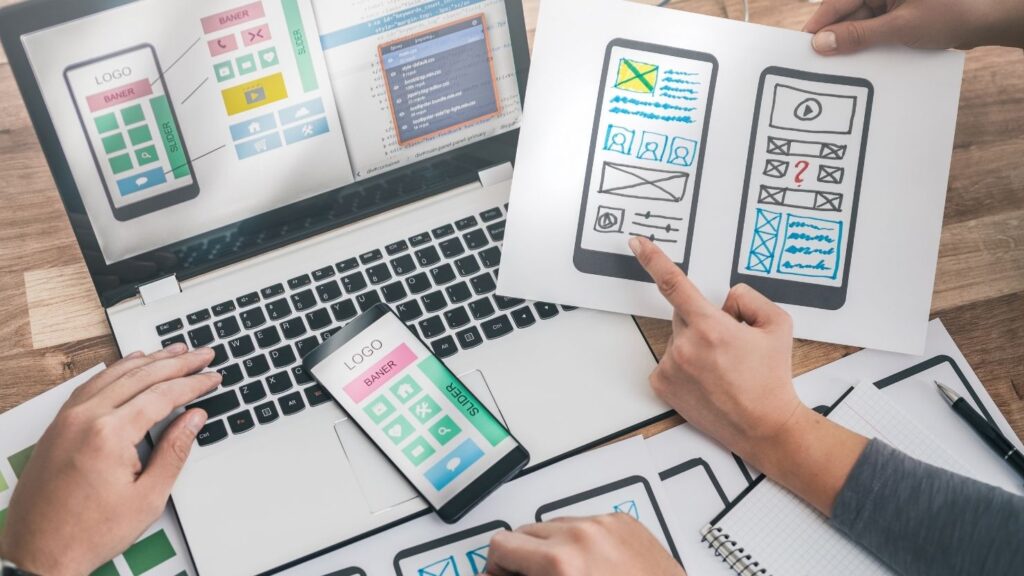 Designers drawing mobile UX app development.
