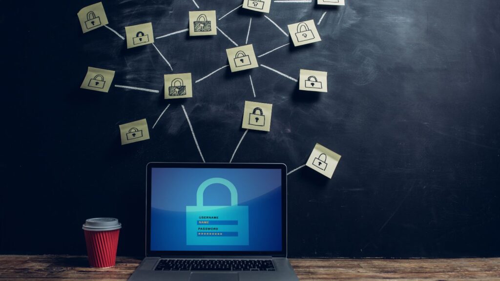 A laptop with an image of a padlock on its screen. Above it are sticky notes with drawing of padlocks.