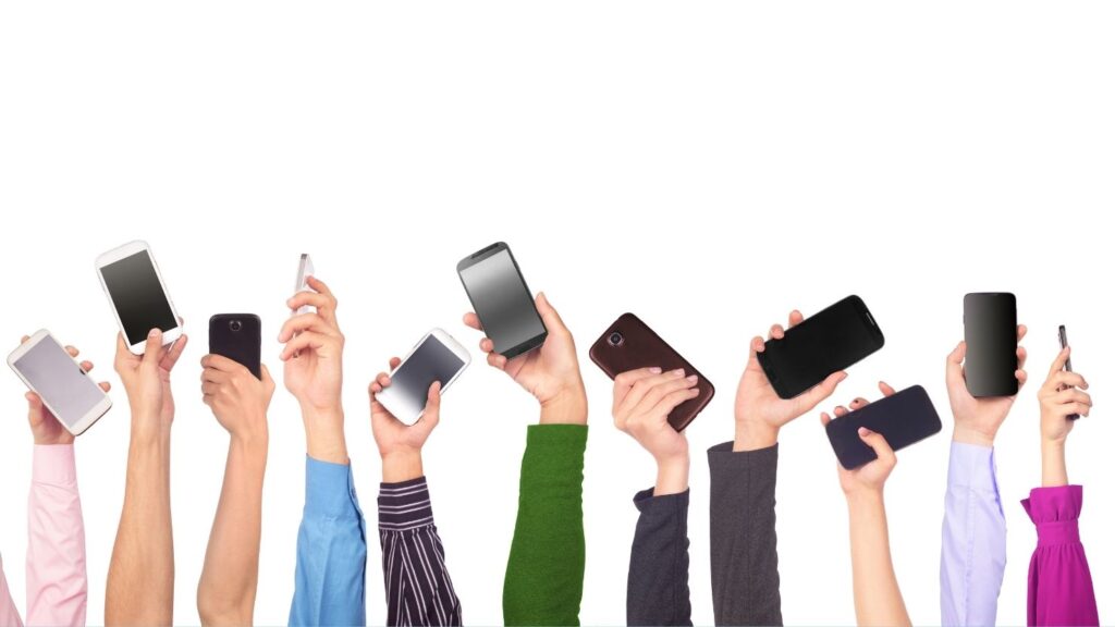 Many hands holding up mobile phones
