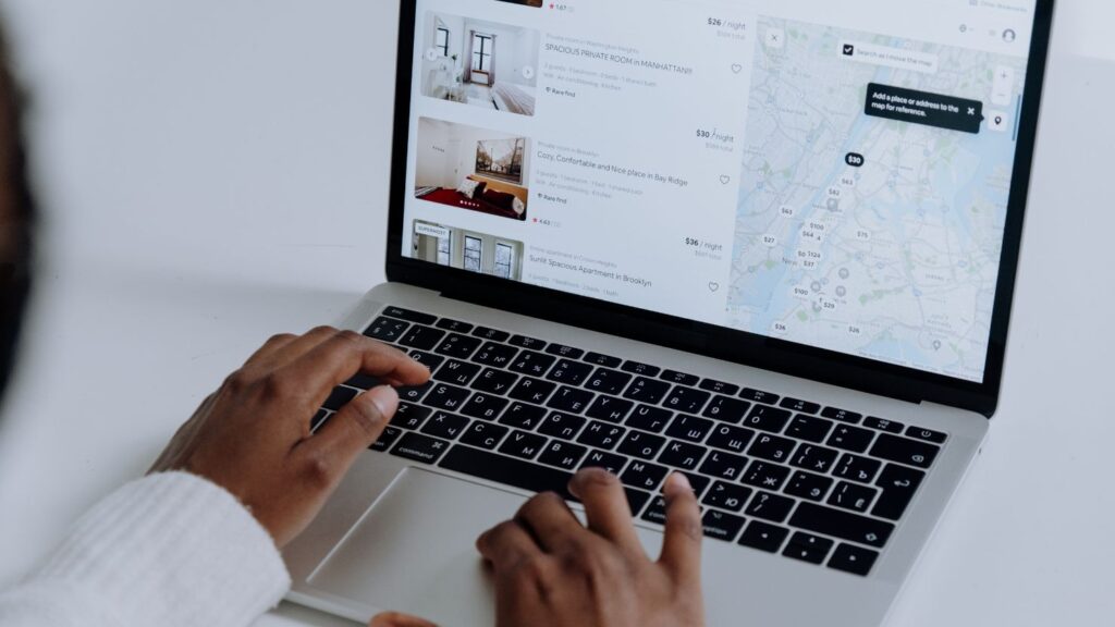 A person looking at the booking page of Airbnb on a laptop