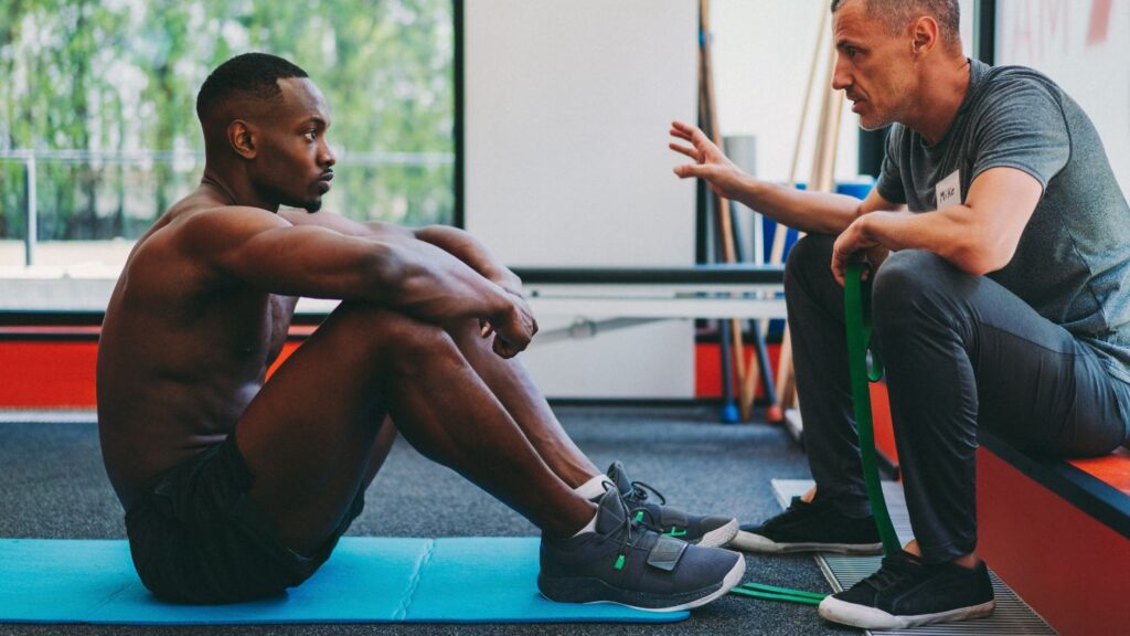 Personal trainer talking with a sporty man about progress