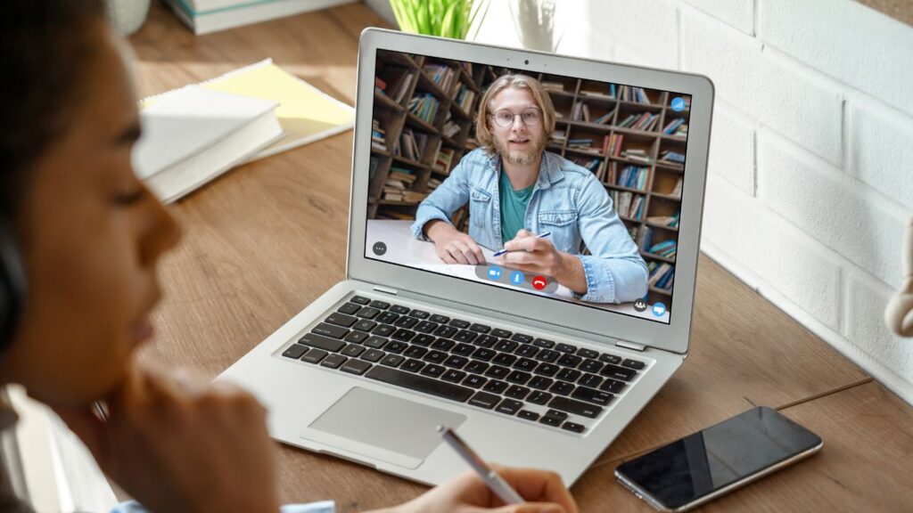 College Student Studying with Online Teacher on Laptop